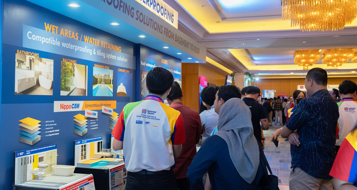 Crowd engaging with Nippon Paint's waterproofing solutions display, featuring various applications for wet areas, including bathrooms, balconies, and swimming pools, highlighting Nippon CEM products for effective waterproofing and tiling systems.