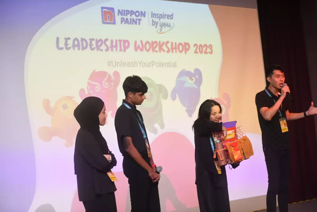 Participants engaged in the Nippon Paint Leadership Workshop 2023, showcasing teamwork and creativity. The event features interactive activities and presentations, emphasizing the theme #UnleashYourPotential.