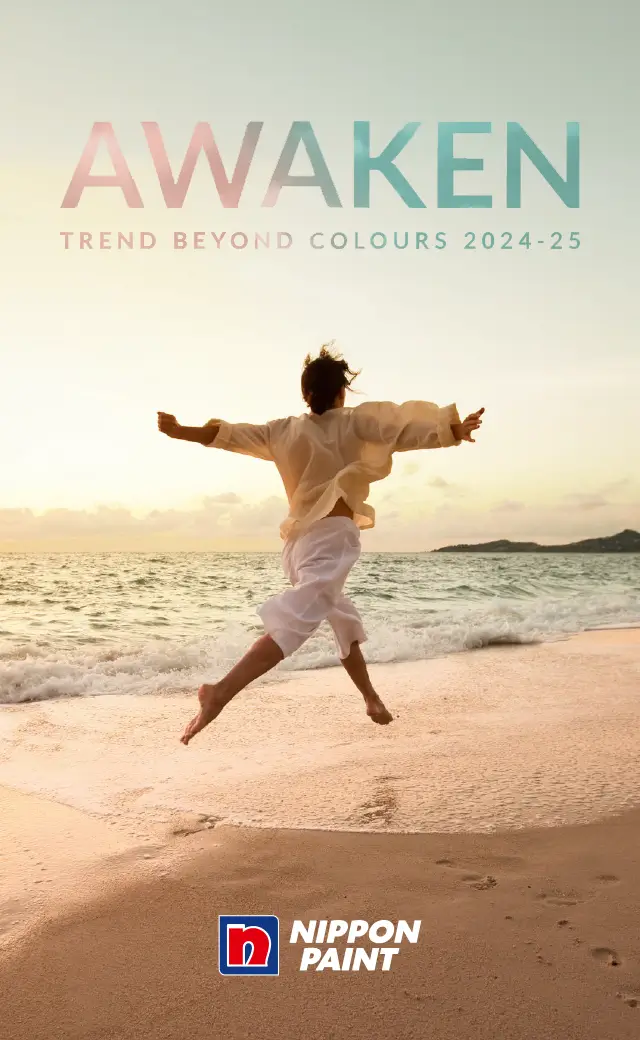 A person joyfully jumping on a beach during sunset, symbolizing freedom and creativity, with the text "AWAKEN: Trend Beyond Colours 2024-25" and Nippon Paint branding displayed prominently.