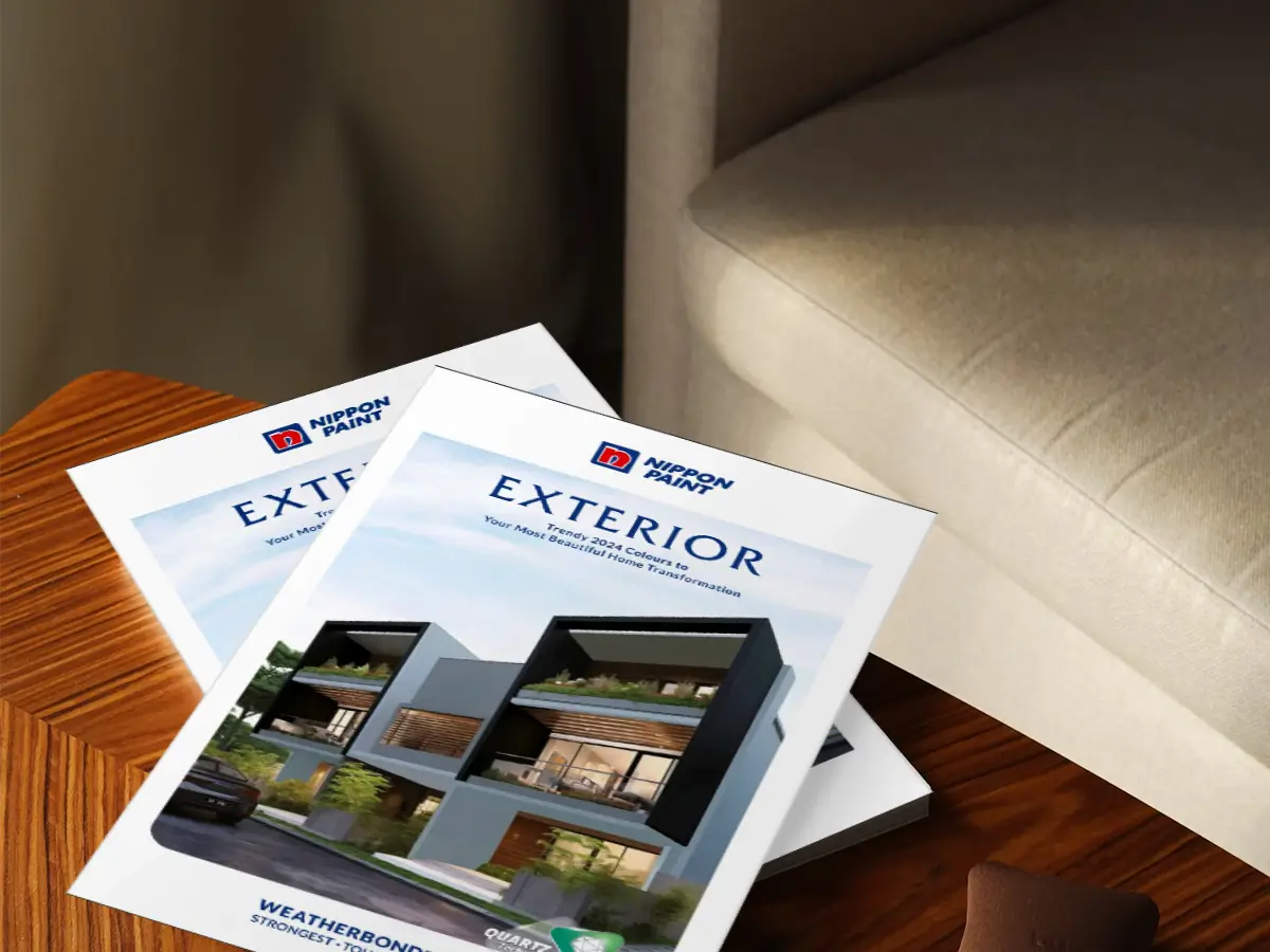 Nippon Paint exterior design brochures displayed on a wooden table, showcasing the Weatherbond product for durable home transformations.