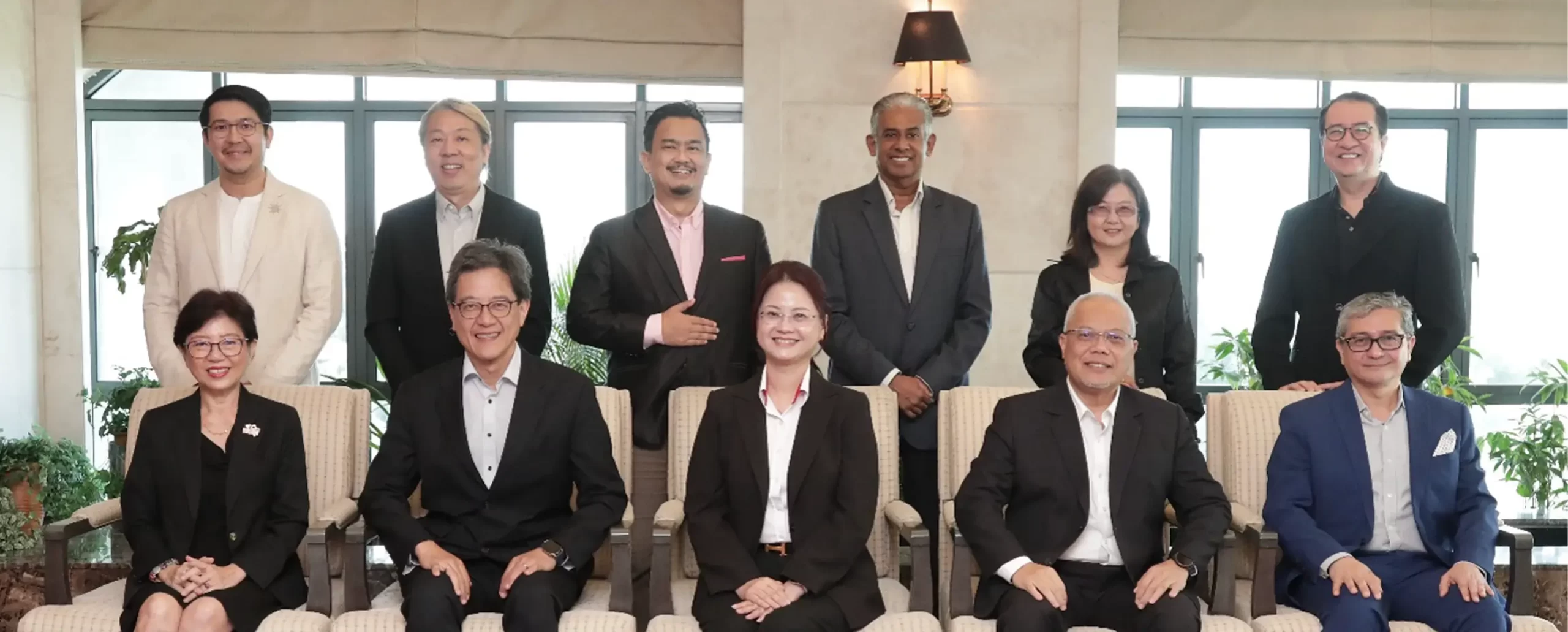 Group photo of Nippon Paint executives and team members in a modern office setting, showcasing collaboration and leadership in the paint industry. The image highlights a diverse group of professionals dressed in business attire, emphasizing Nippon Paint's commitment to innovation and teamwork.