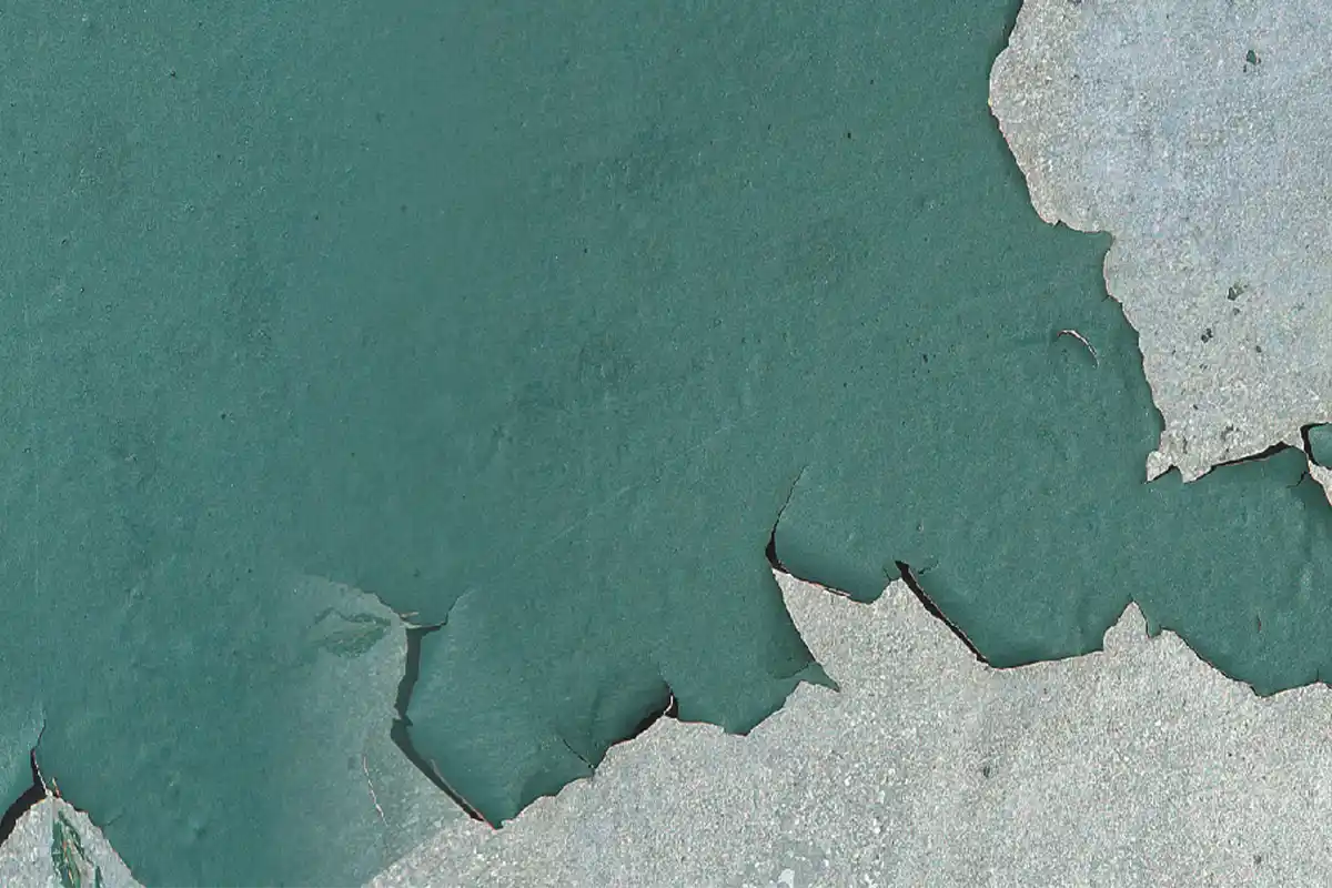 Wall paint peeling on blue green interior wall