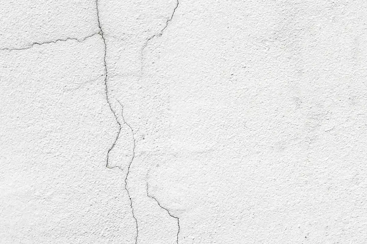 Hairline cracks on white exterior wall