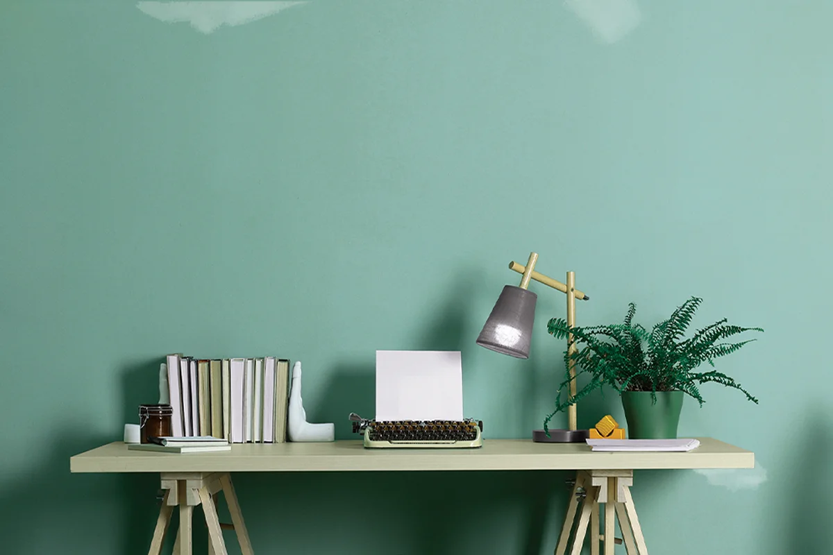 White patches on blue green interior wall with desk